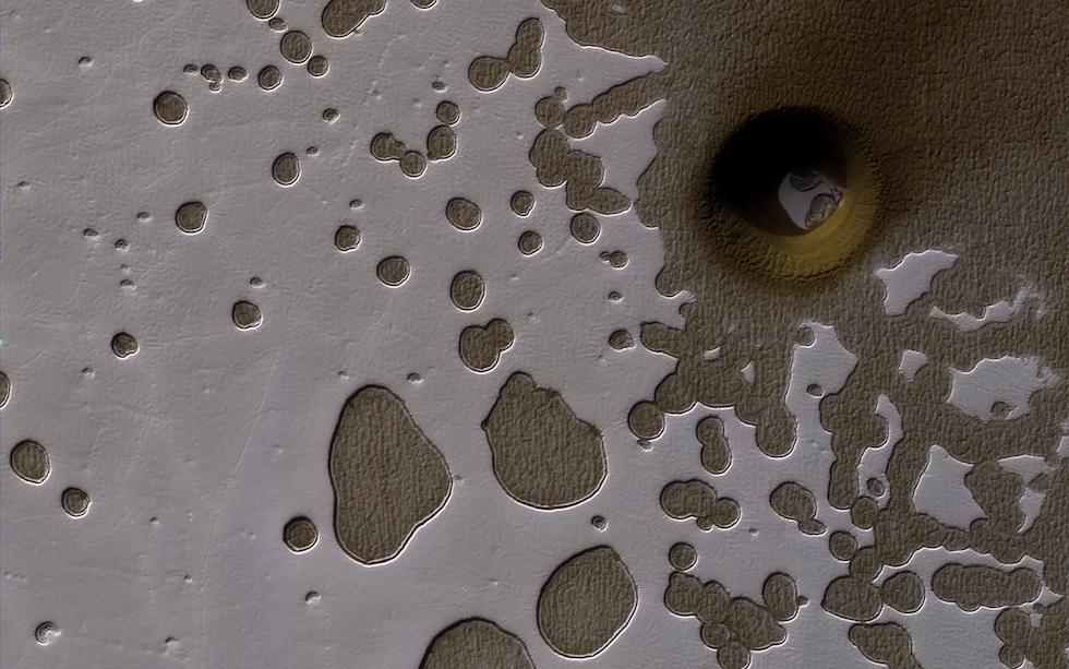 L’emisfero meridionale di Marte nella tarda estate, con il Sole basso all’orizzonte che illumina una distesa di ghiaccio di anidride carbonica, nei pressi di quello che potrebbe essere un cratere o parte del suolo crollata per altri motivi. L’immagine è stata realizzata dalla sonda Mars Reconnaissance Orbiter della NASA ed è stata diffusa nell’agosto di quest’anno.

NASA/JPL-Caltech/Univ. of Arizona